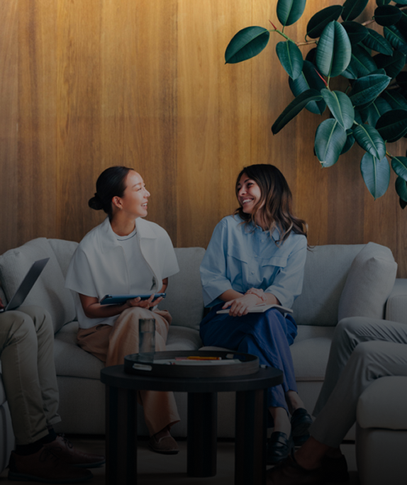 People sitting on a couch, smiling, talking.